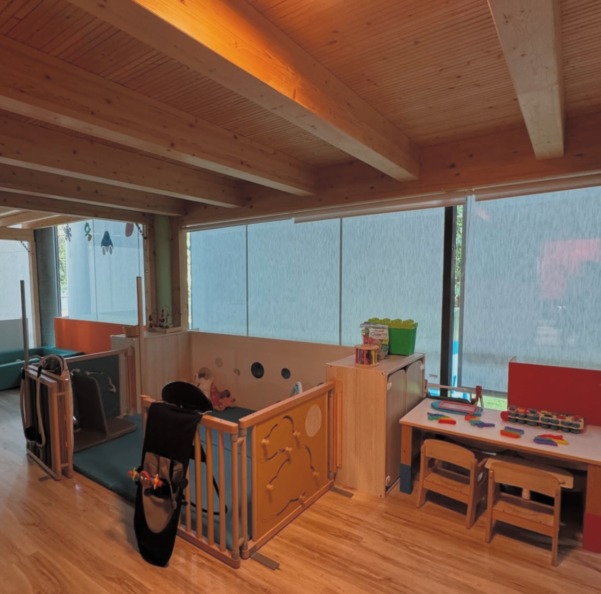 Babies' room at Au Petit Bonheur nursery in Clarens — firm mats and low furniture for free movement (Loczy/Pikler approach)